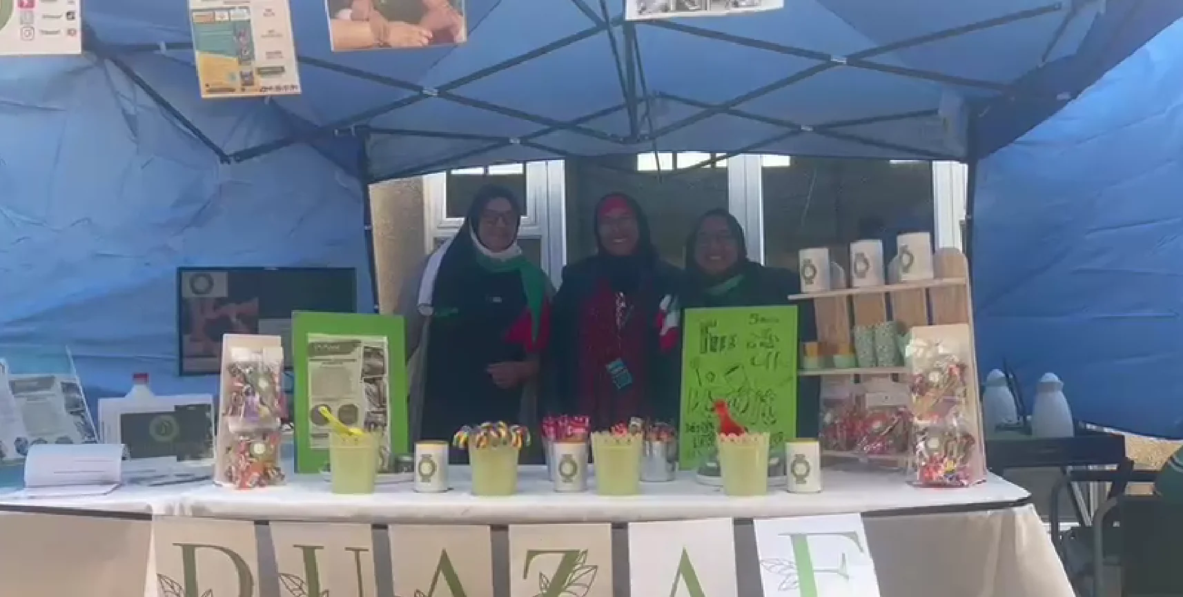 Small business owner selling handmade products at a market stall supported by DUAZAF